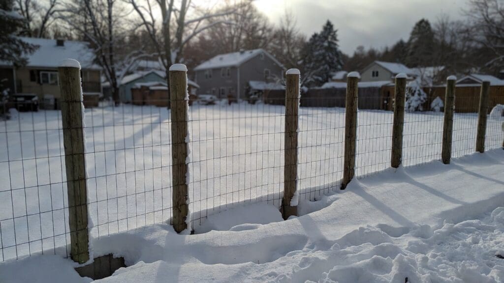A newly installed frost fence with deep concrete footings in a snowy backyard Gardenfrontier A newly installed frost fence with deep concrete footings in a snowy backyard
