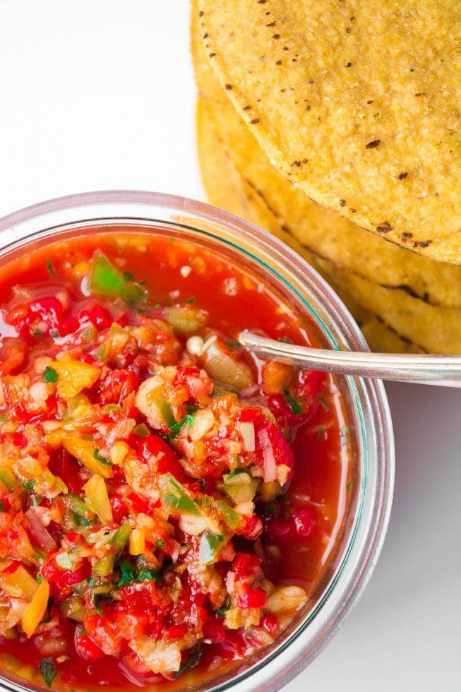 A bowl of fresh Roasted Red Pepper Salsa served with fish Gardenfrontier A bowl of vibrant roasted red pepper salsa placed next to a grilled fish fillet