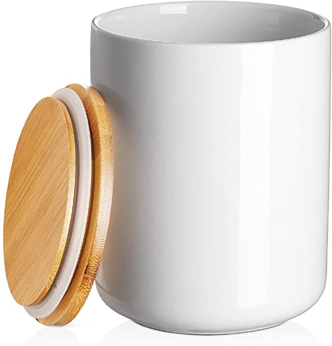A white ceramic kitchen compost bin Gardenfrontier A stylish white ceramic indoor compost bin sitting on a kitchen counter