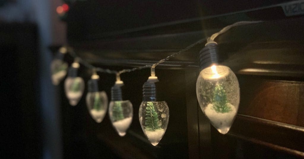 A closeup of beautiful Mini Snow Globe Lights Gardenfrontier A string of Christmas lights where each bulb looks like a miniature snow globe with a tiny tree inside
