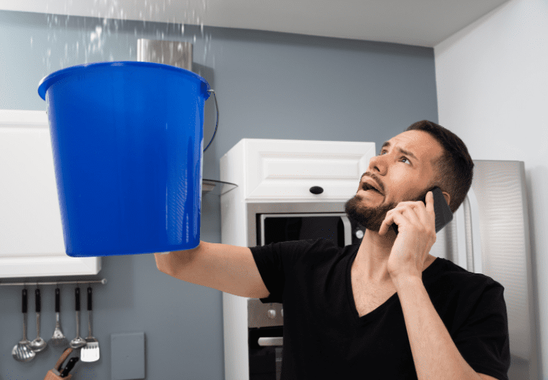 How To Repair A Leaking Ceiling Gardenfrontier A homeowner inspecting a severe water leak and bubbling paint on a living room ceiling