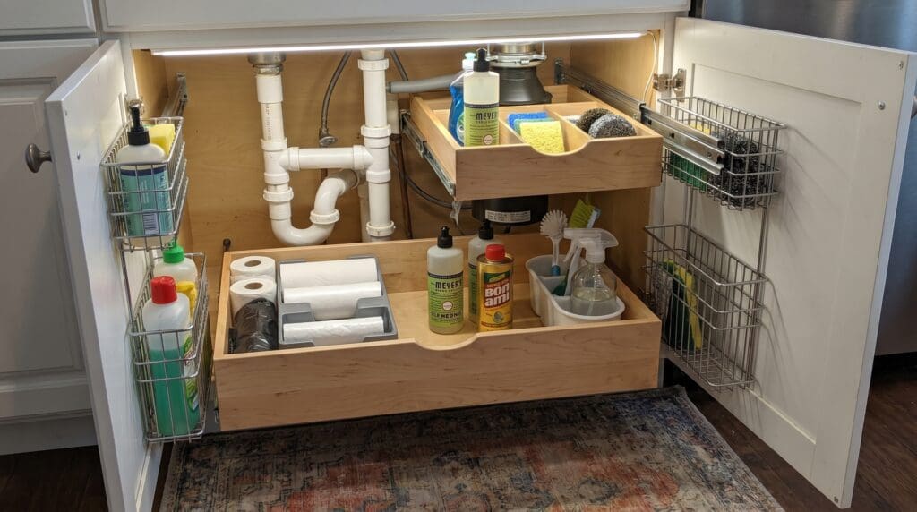 undersinkpulloutdrawers Gardenfrontier Under sink pull out drawers installed below a kitchen sink with cleaning supplies organized around plumbing pipes